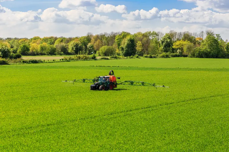 Photo of a tracker spraying glyphosate on crops